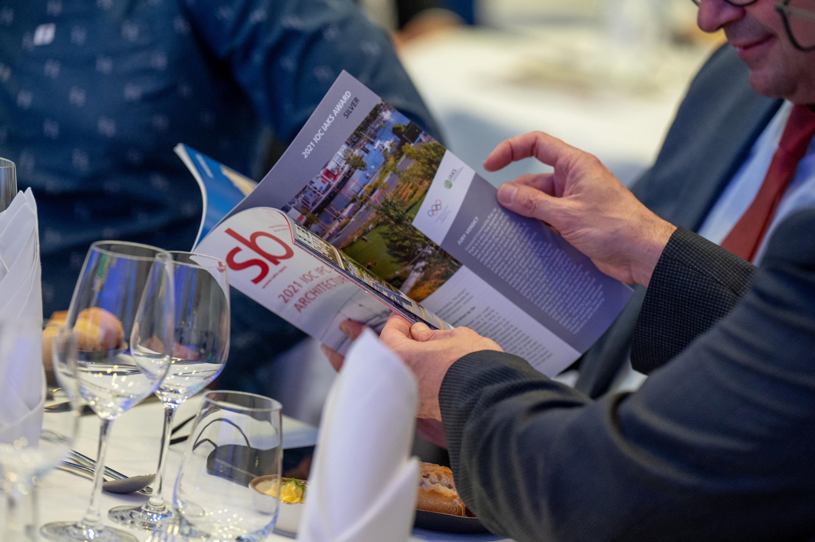 Person reading IAKS sb magazine on a table